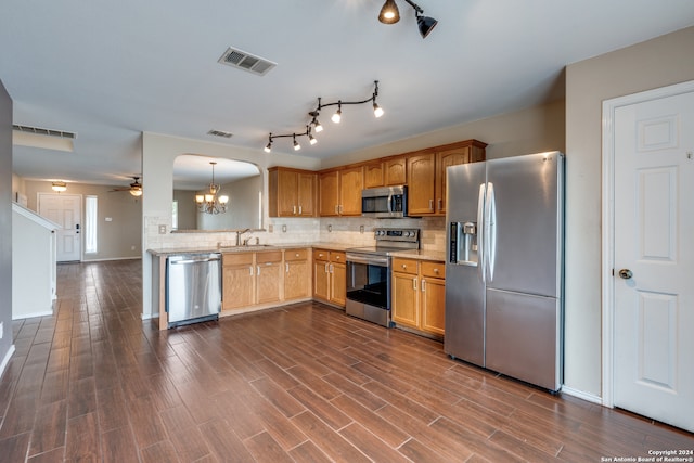 kitchen with stainless steel appliances, sink, dark hardwood / wood-style floors, backsplash, and pendant lighting