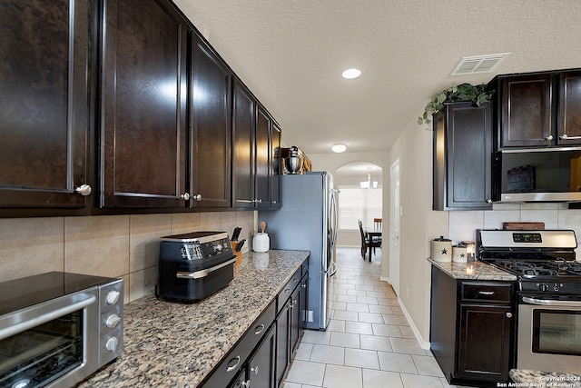 kitchen with tasteful backsplash, appliances with stainless steel finishes, and stone countertops