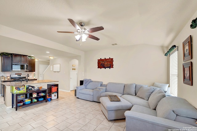 living room featuring ceiling fan, sink, and vaulted ceiling