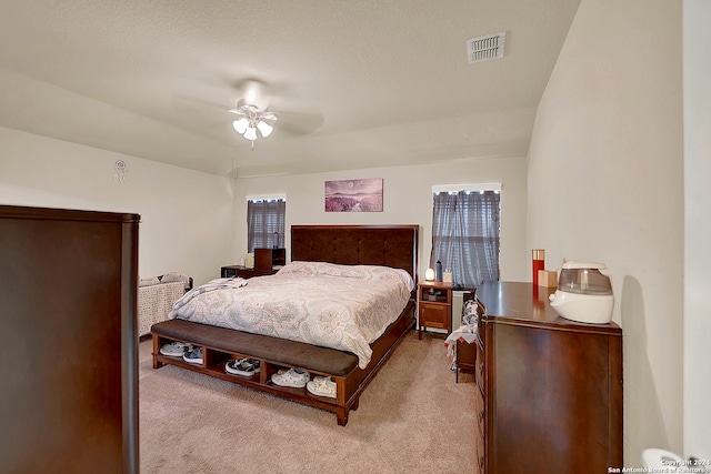 carpeted bedroom with a textured ceiling and ceiling fan