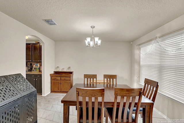 dining space with an inviting chandelier and a textured ceiling