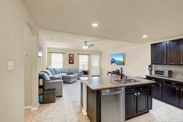 kitchen featuring light tile patterned floors, sink, stainless steel dishwasher, ceiling fan, and a kitchen island with sink