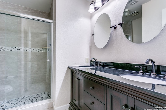 bathroom with vanity and a shower with shower door