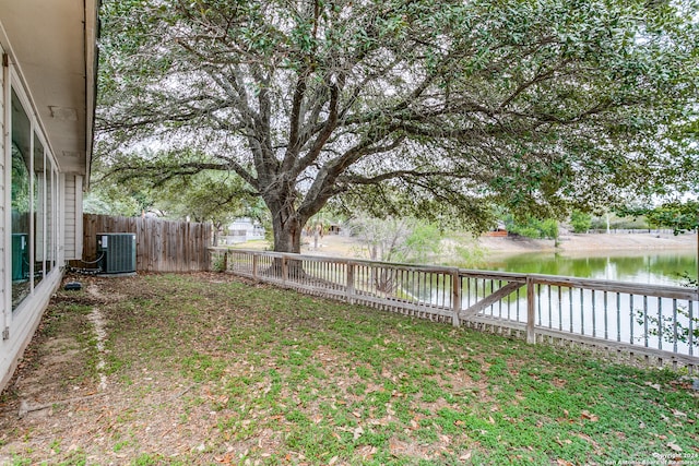 view of yard featuring central air condition unit and a water view