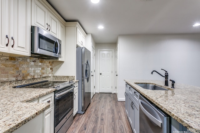 kitchen featuring light stone counters, appliances with stainless steel finishes, dark hardwood / wood-style floors, decorative backsplash, and sink