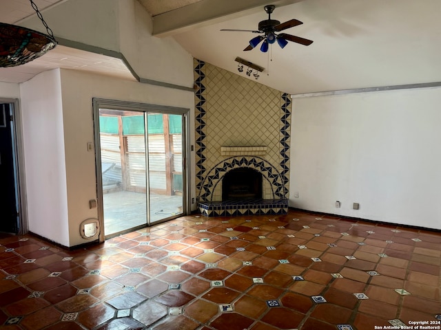 unfurnished living room with lofted ceiling with beams, dark tile patterned floors, ceiling fan, and a fireplace