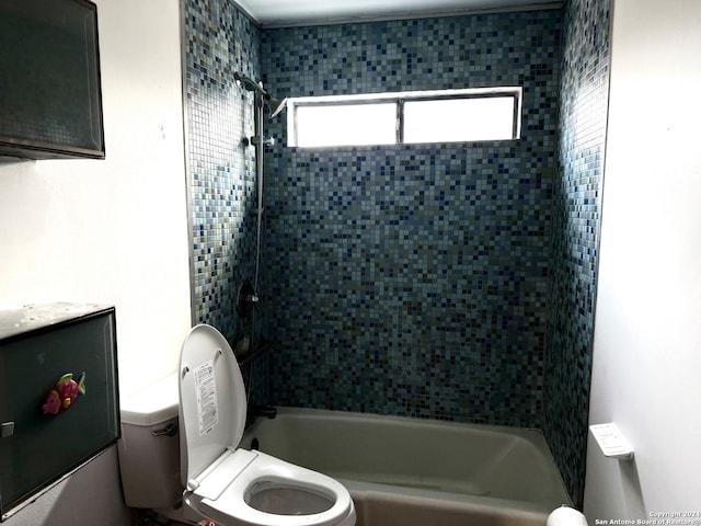 full bathroom featuring vanity, tiled shower / bath, and toilet