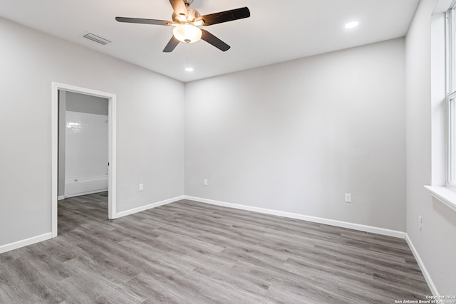 spare room featuring light hardwood / wood-style floors, ceiling fan, and a healthy amount of sunlight