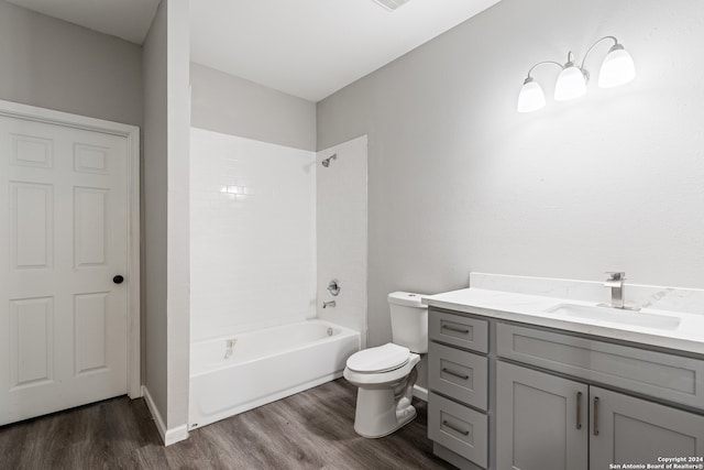 full bathroom with hardwood / wood-style flooring, vanity, toilet, and shower / washtub combination