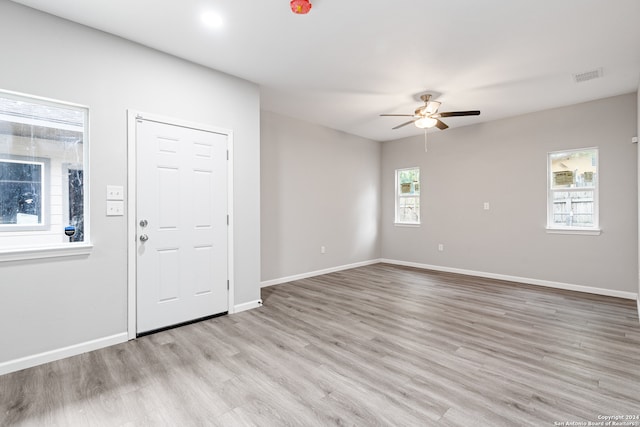 spare room featuring light hardwood / wood-style flooring, a healthy amount of sunlight, and ceiling fan