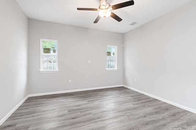 unfurnished room with light hardwood / wood-style floors, a healthy amount of sunlight, and ceiling fan