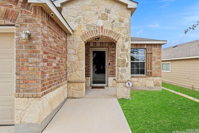 doorway to property featuring a garage and a yard