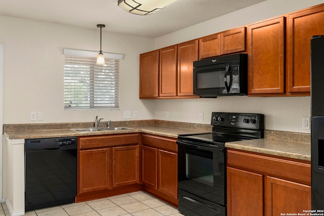 kitchen featuring pendant lighting, black appliances, light tile patterned floors, and sink