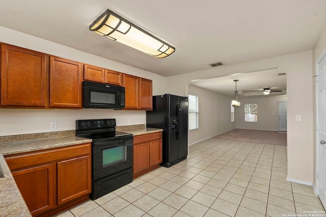 kitchen with pendant lighting, ceiling fan with notable chandelier, black appliances, and light tile patterned floors