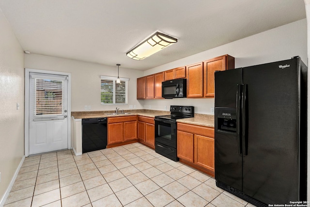 kitchen with pendant lighting, black appliances, sink, and light tile patterned floors