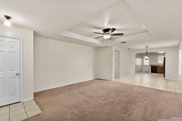 unfurnished living room featuring light colored carpet, ceiling fan, and a tray ceiling