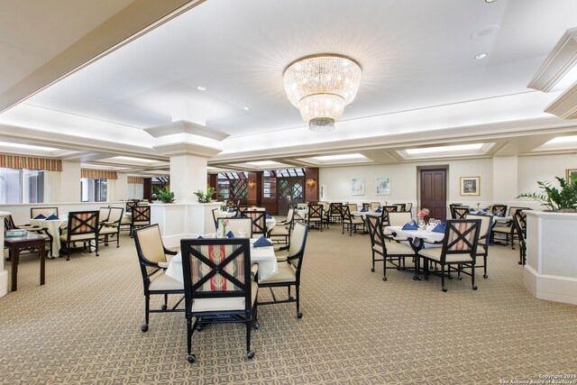 dining space featuring light colored carpet and a chandelier