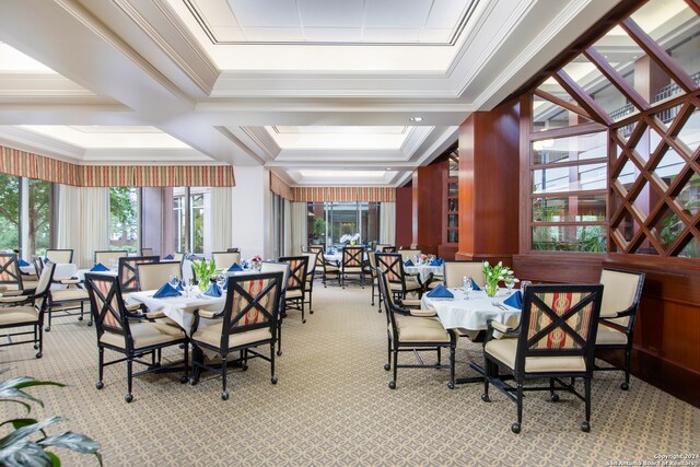 dining space with ornamental molding and light colored carpet