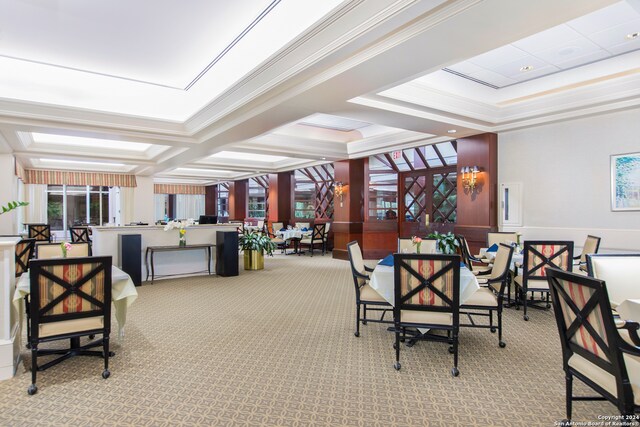 carpeted dining space with crown molding