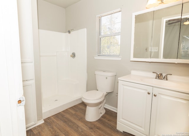 bathroom featuring a shower, hardwood / wood-style flooring, vanity, and toilet