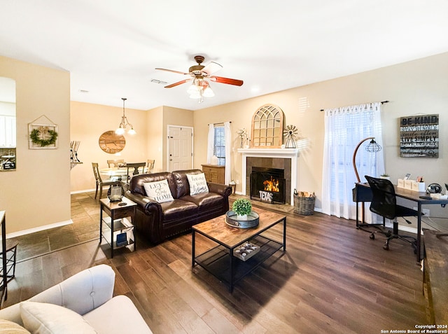 living room with dark wood-type flooring, a fireplace, and ceiling fan