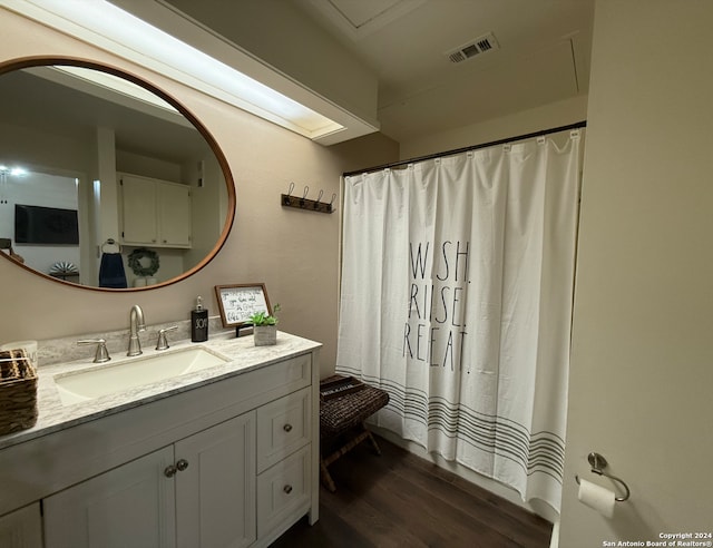 full bathroom featuring wood finished floors and vanity