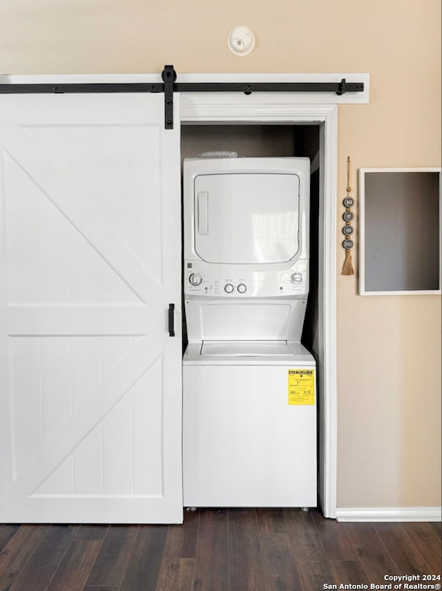 clothes washing area featuring stacked washer / drying machine and dark hardwood / wood-style floors