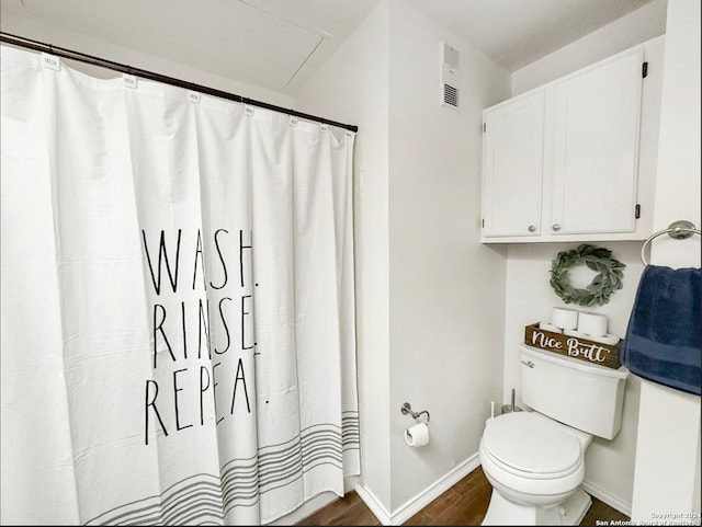 bathroom with wood finished floors, baseboards, and toilet