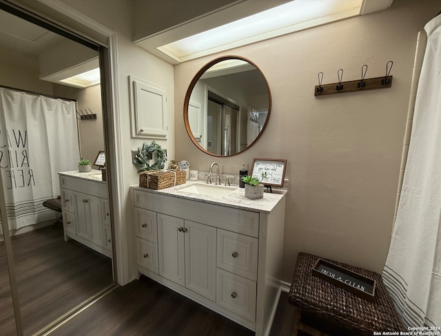 full bathroom featuring wood finished floors and vanity