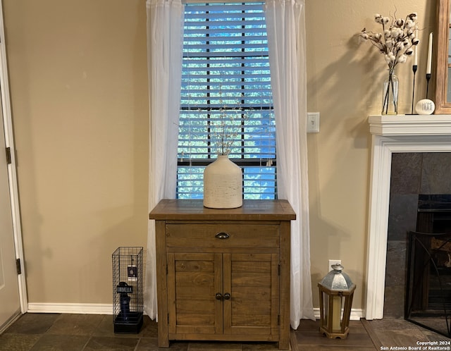 detailed view of baseboards and a tiled fireplace