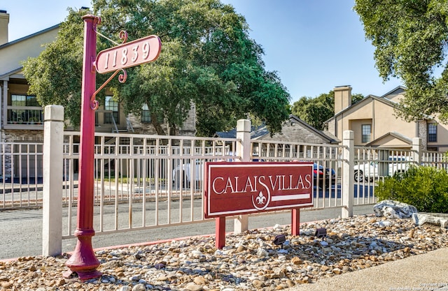 community / neighborhood sign featuring fence