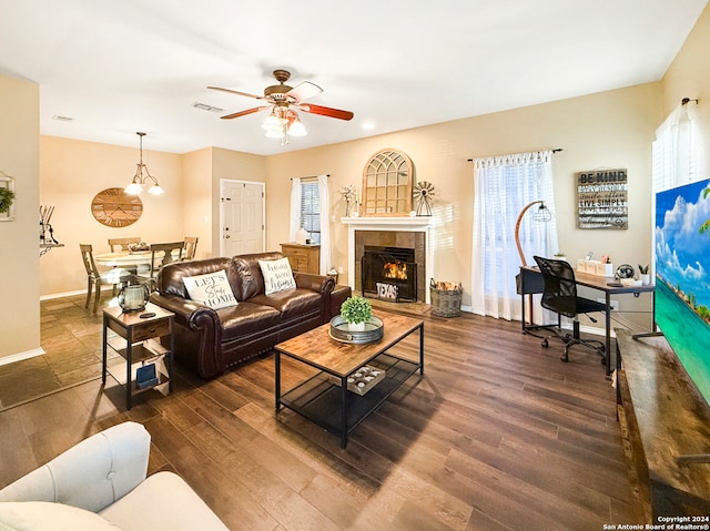 living room featuring a fireplace, a healthy amount of sunlight, and dark hardwood / wood-style floors