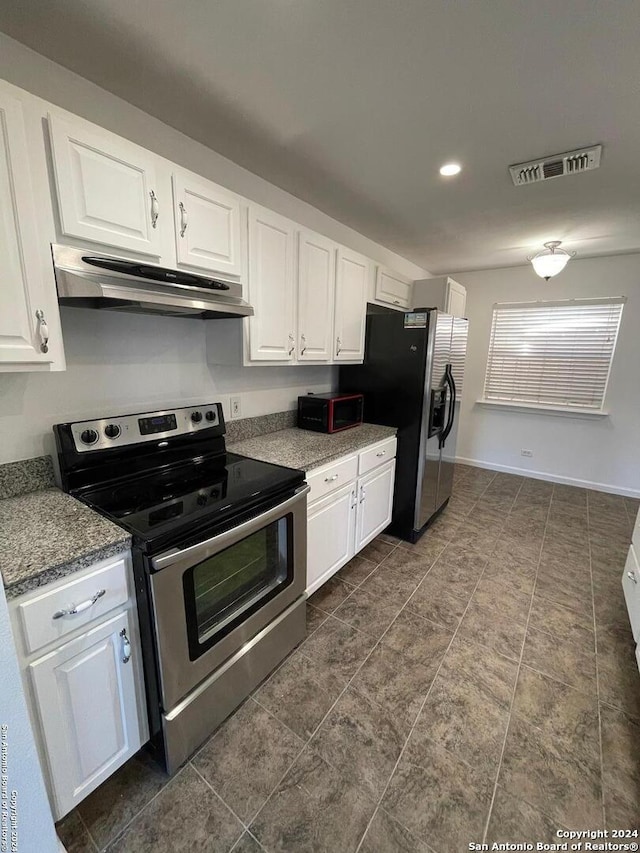 kitchen featuring dark stone counters, appliances with stainless steel finishes, and white cabinets