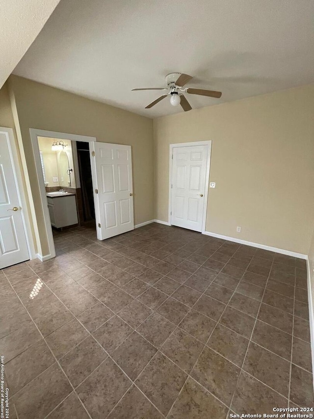 unfurnished room featuring dark tile patterned flooring and ceiling fan