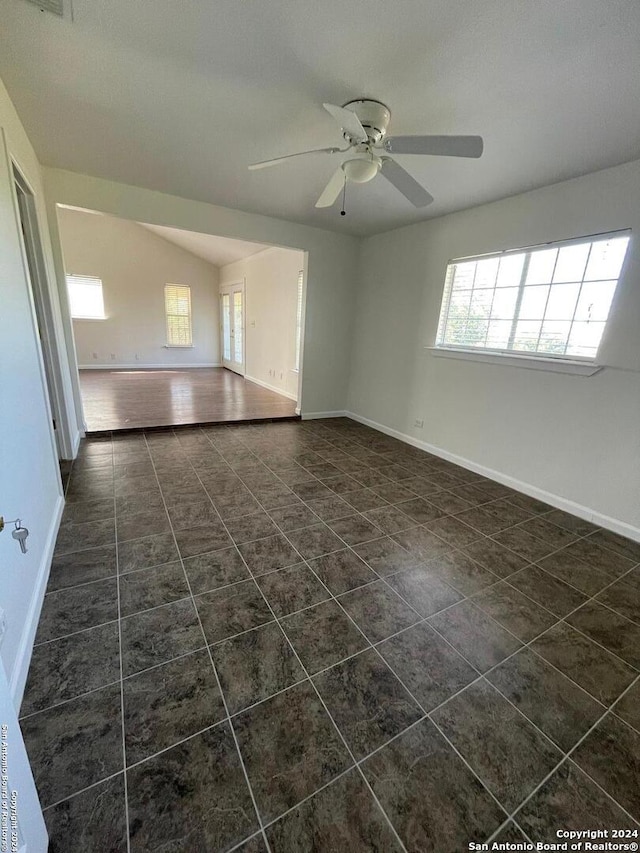 spare room featuring ceiling fan and dark tile patterned floors