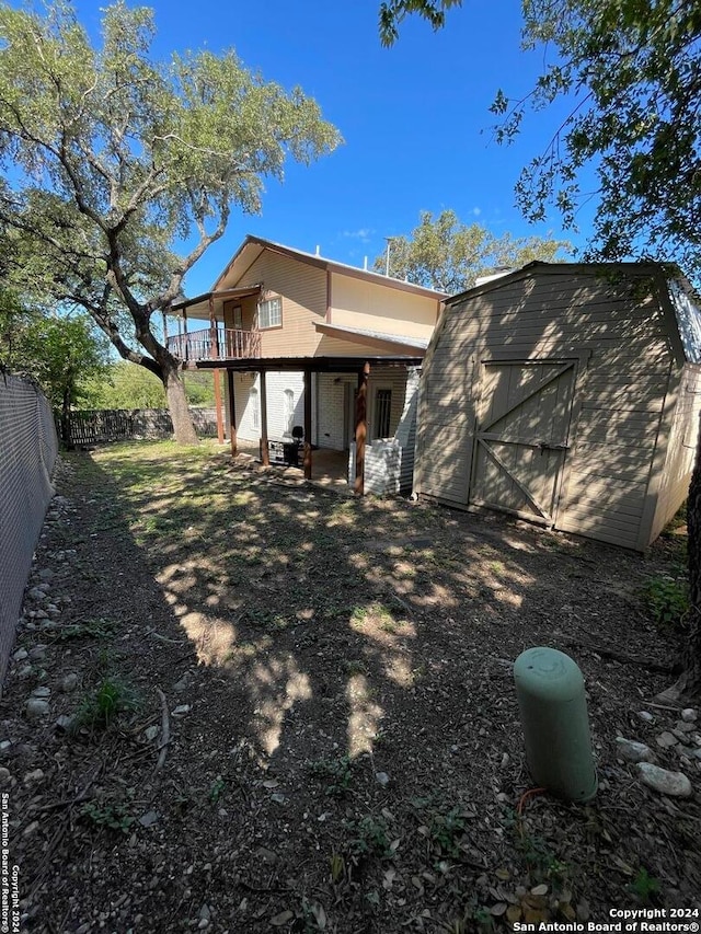 rear view of house with a storage shed