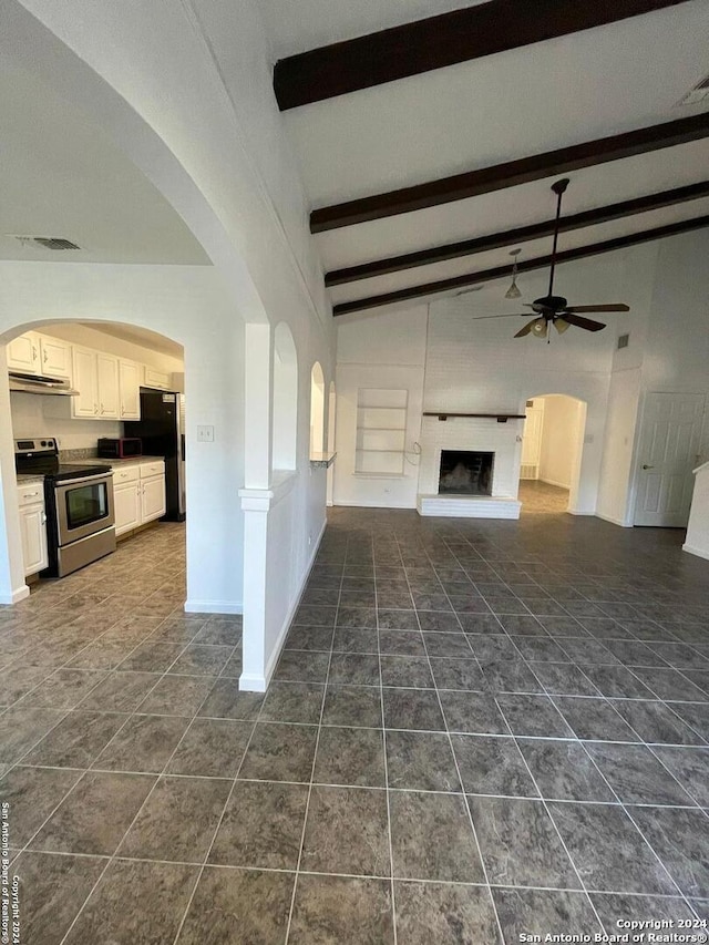 unfurnished living room with high vaulted ceiling, beamed ceiling, ceiling fan, and dark tile patterned flooring