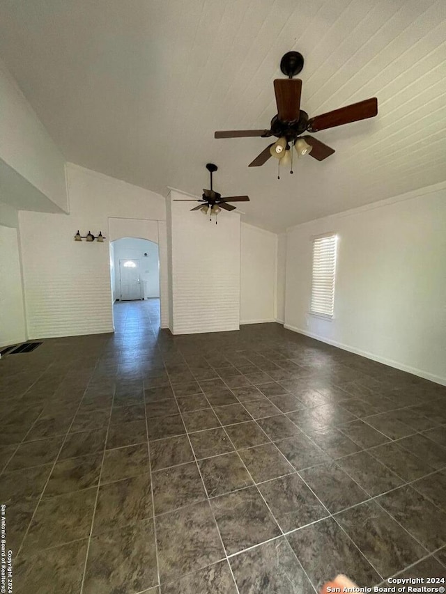 unfurnished room featuring dark tile patterned flooring, vaulted ceiling, and ceiling fan