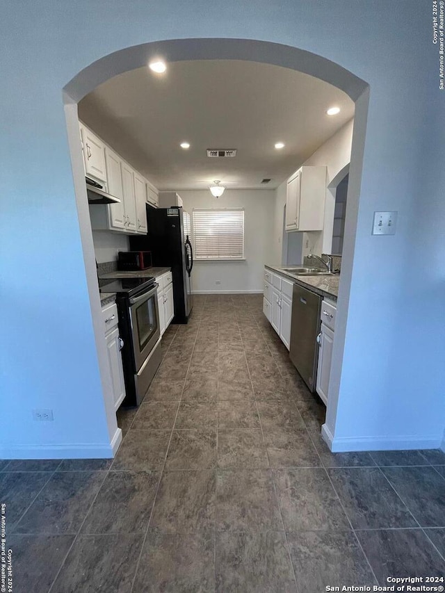 kitchen with appliances with stainless steel finishes, sink, and white cabinets