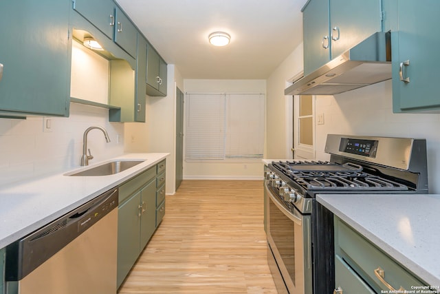 kitchen featuring stainless steel appliances, light hardwood / wood-style floors, extractor fan, sink, and backsplash