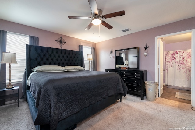 carpeted bedroom with connected bathroom and ceiling fan