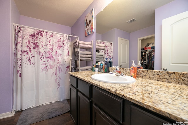 bathroom with vanity, hardwood / wood-style floors, and a textured ceiling