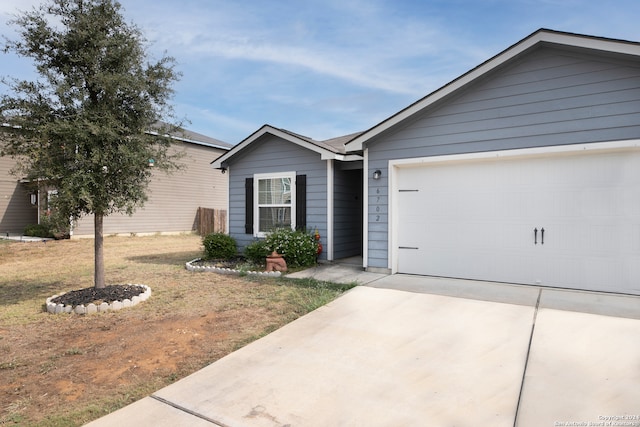 ranch-style home with a garage and a front lawn