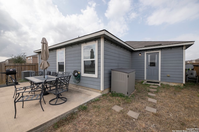 back of property with cooling unit and a patio area