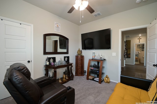 living room with ceiling fan and carpet