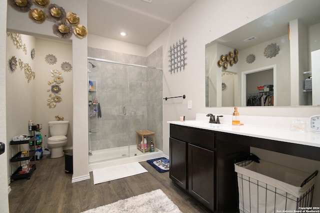 bathroom with hardwood / wood-style flooring, vanity, toilet, and an enclosed shower