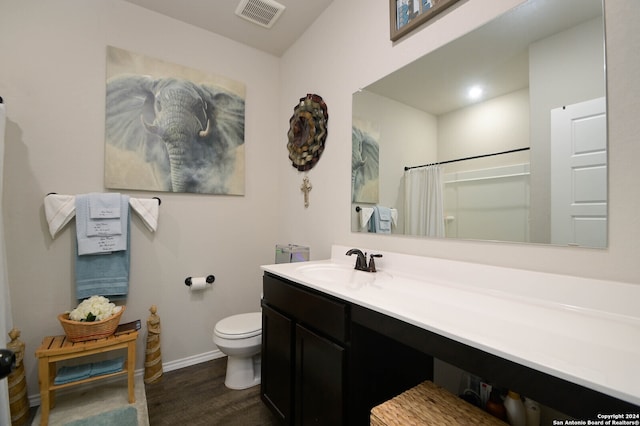 bathroom with hardwood / wood-style floors, curtained shower, vanity, and toilet