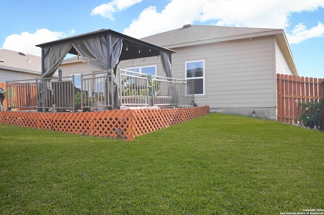 rear view of house featuring a lawn and a wooden deck