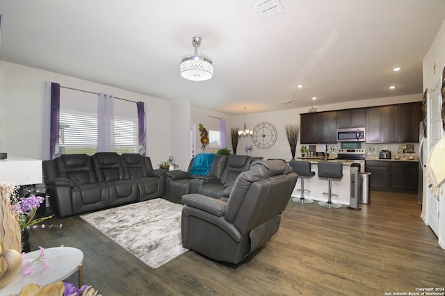 living room featuring dark wood-type flooring and a chandelier