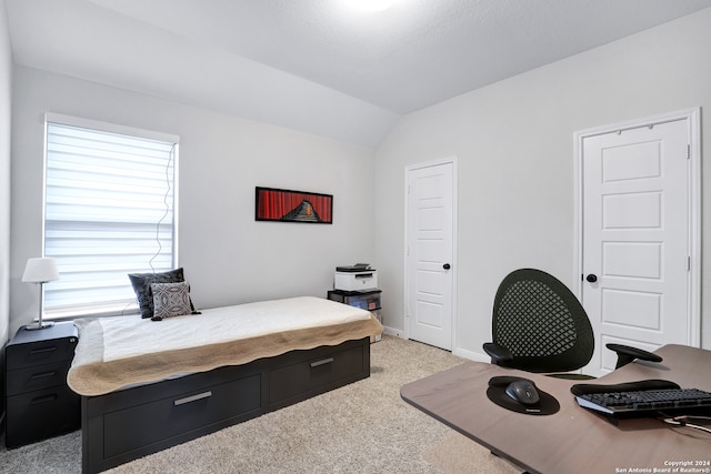 bedroom featuring light colored carpet and vaulted ceiling